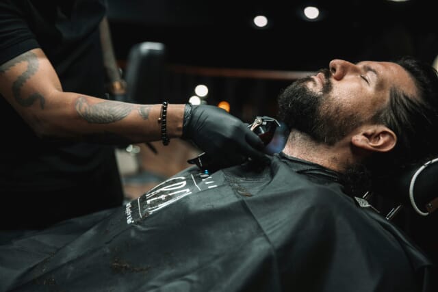 Profesional independiente cortando el pelo de barba
